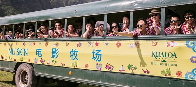 A group of Nu Skin Sales Leaders from Greater China pose for a picture while inside a garden car. 